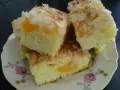 Saftiger Mandarinen Kuchen mit Mandelblättchen, auf einem Teller mit Blumenmuster.