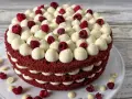 Ein mehrschichtiger Red Velvet Kuchen mit weißer Creme und Himbeeren.