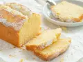 Ein goldbrauner Sandkuchen, bestäubt mit Puderzucker, wartet darauf, nach diesem einfachen Sandkuchen Rezept gebacken zu werden.
