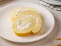 Zwei Scheiben einer leichten Biskuitrolle mit cremiger Füllung, perfekt für ein Zitronenrolle Rezept.