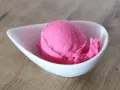 Ein Löffel leuchtend pinkes Eis in einer weißen Schale. Vielleicht ist das die Antwort auf die Frage, warum es kein Kirscheis gibt – weil dieses hier so gut ist!