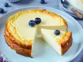 Ein köstlicher, gesunder Kuchen mit Blaubeeren, der auf einem Teller serviert wird. Ein Stück ist bereits herausgeschnitten.