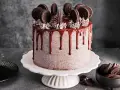 Ein köstlicher Oreo Kuchen mit Schokoladenglasur und vielen Oreos obendrauf.