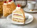Ein Stück Frankfurter Kranz mit Buttercreme, Marmelade und Nüssen, garniert mit einer Kirsche. Ein Genuss für jeden Kaffeetisch.