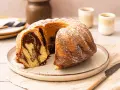 Ein saftiger Marmorkuchen, bestäubt mit Puderzucker, wartet auf dem Teller. Perfekt für den Kaffeetisch.