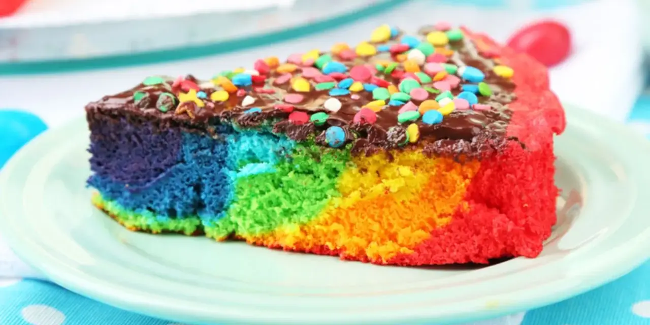 Buntes Kuchenstück mit Schokoladenglasur und Streuseln, perfekt für ein Papageienkuchen Rezept.