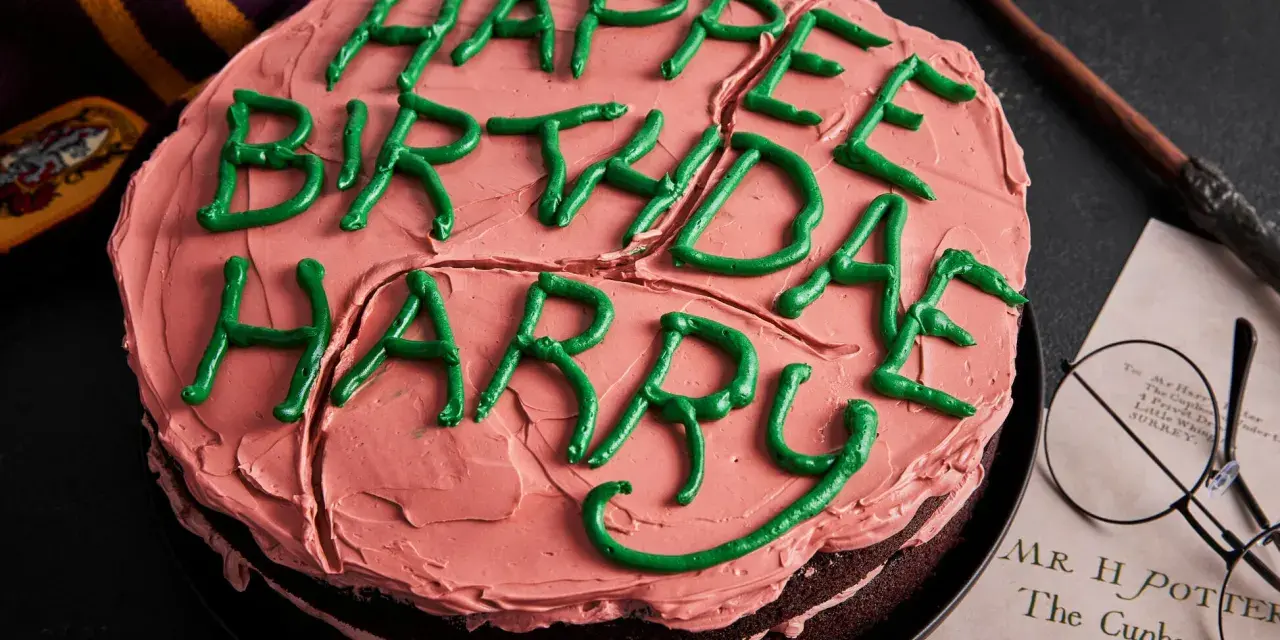 Ein Harry Potter Kuchen mit rosa Zuckerguss und grüner Schrift "Happy Birthday Harry". Daneben liegen ein Schal, eine Brille und ein Brief.