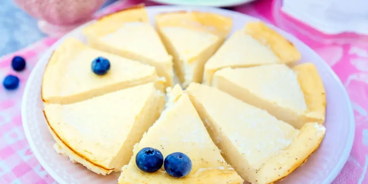 Ein köstlicher low carb Kuchen, in Stücke geschnitten und mit Blaubeeren garniert, wartet auf Genuss.