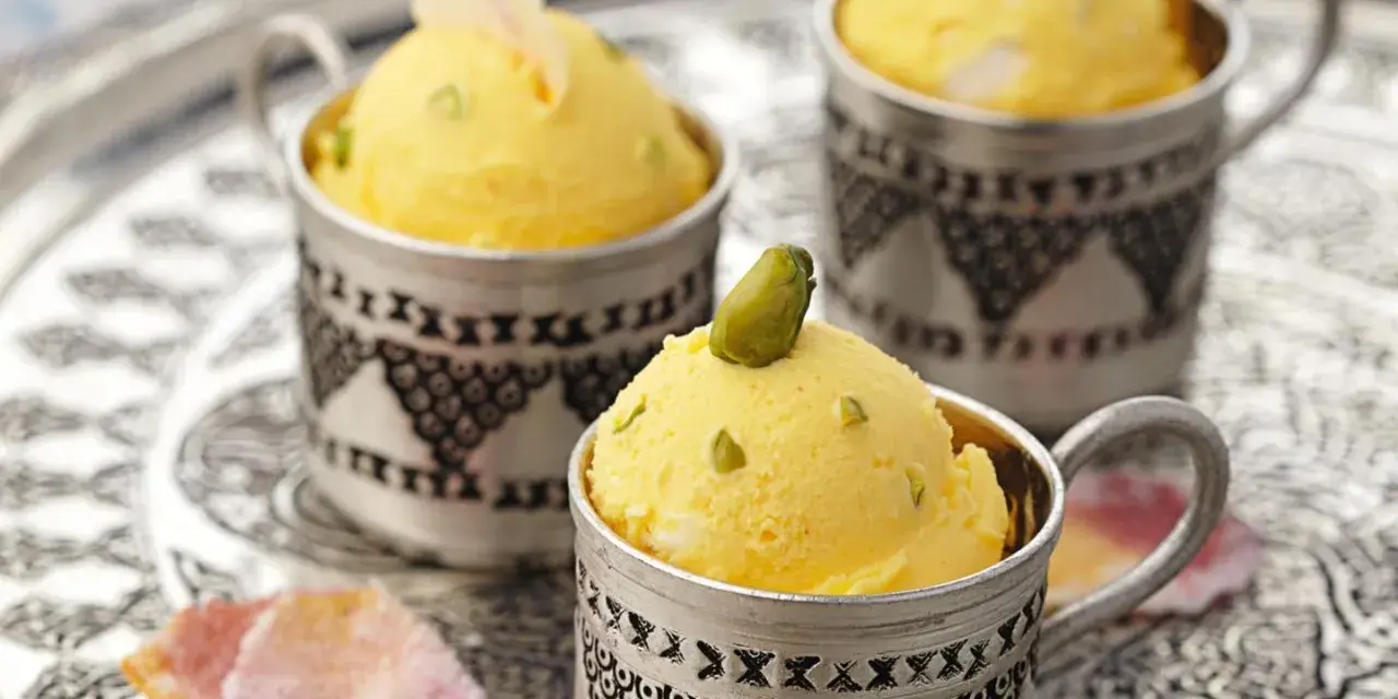 Gelbes Eis mit Pistazien in silbernen Bechern. Die süße Glucose-Verwendung sorgt für die cremige Konsistenz.