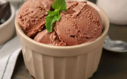 Schokoladeneis-Kugeln in einer Schale, garniert mit Minze. Perfekt, wenn du **eisbasis selber machen** möchtest.