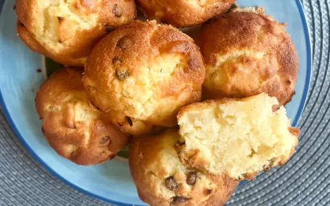 Saftige Apfelmuffins, perfekt für ein schnelles apfelmuffins rezept. Einer ist aufgeschnitten und zeigt die lockere Krume.
