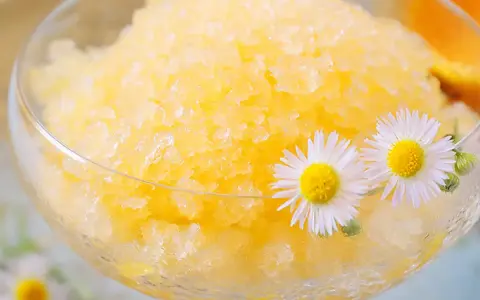 Erfrischendes Zitronen-Granita-Rezept in einem Glas, garniert mit Gänseblümchen. Perfekt für heiße Tage!