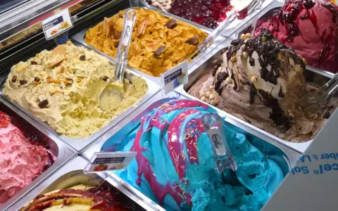 Verschiedene Sorten Eis: Pistazie, Karamell, Beeren, Schoko-Nuss und ein blaues Eis mit bunten Streuseln. Ein Fest für die Sinne!