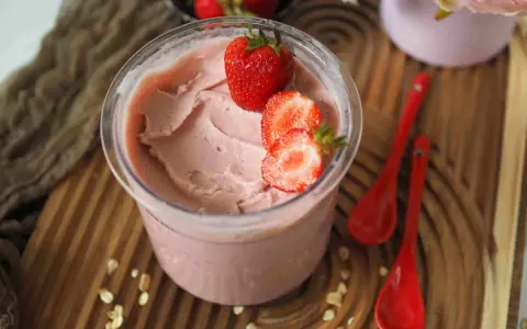 Cremiges Kefir Eis mit frischen Erdbeeren garniert, bereit zum Genießen.