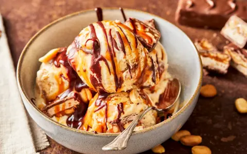 Schokoladiges Eis mit Karamell und Erdnüssen, perfekt für alle, die Snickers Eis selber machen wollen.