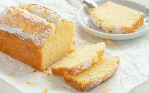 Ein goldbrauner Sandkuchen, bestäubt mit Puderzucker, wartet darauf, nach diesem einfachen Sandkuchen Rezept gebacken zu werden.