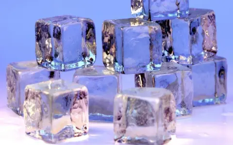 Eiswürfel stapeln sich, glitzernd und durchscheinend. Sie zeigen, wie kalt Eis werden kann, mit gefrorenen Einschlüssen und scharfen Kanten.