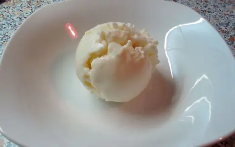 Eine Kugel cremiges Quark Eis in einer weißen Schale, bereit zum Genießen.