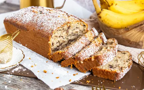 Saftiger Bananenkuchen mit Schokostückchen, bestäubt mit Puderzucker. Ein köstliches bananenkuchen rezept für jeden Anlass.
