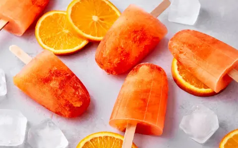 Erfrischendes Aperol Eis mit Orangenscheiben und Eiswürfeln. Perfekt für heiße Sommertage.