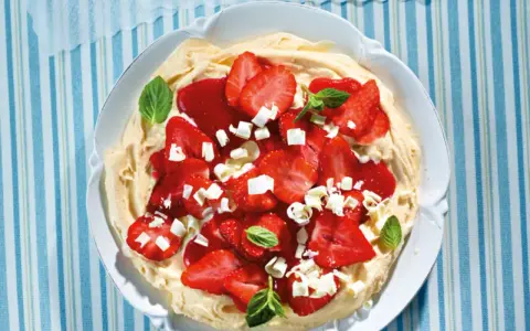 Eine köstliche Eiscreme-Pizza mit frischen Erdbeeren, weißer Schokolade und Minze.