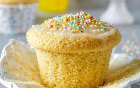 Ein Fanta-Muffin mit Zuckerguss und bunten Streuseln, bereit zum Genießen.