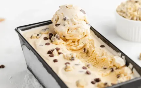 Cremiges Cookie Dough Eis mit Schokoladenstückchen in einer rechteckigen Form.