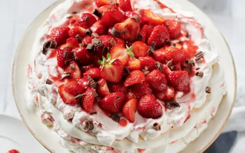 Ein köstliches Pavlova Rezept mit frischen Erdbeeren und Schokostreuseln.