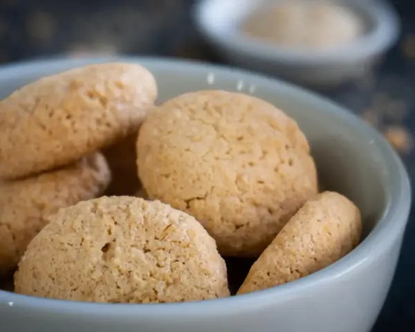 Kleine, goldbraune Amarettini in einer Schale. Dieses Amarettini Rezept ist einfach und gelingt immer.