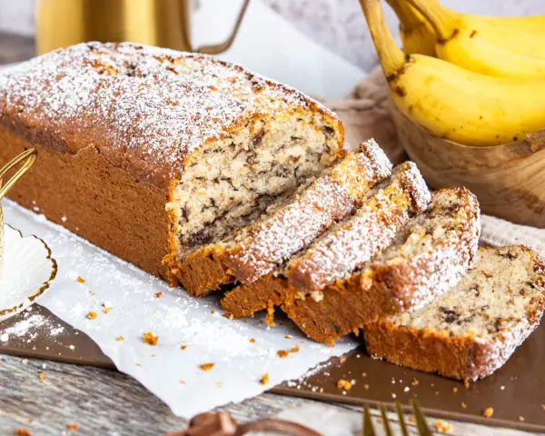 Saftiger Bananenkuchen mit Schokostückchen, bestäubt mit Puderzucker. Ein köstliches bananenkuchen rezept für jeden Anlass.