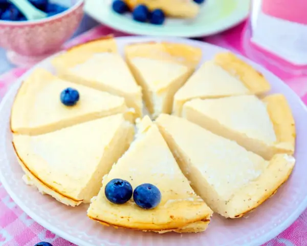 Ein köstlicher low carb Kuchen, in Stücke geschnitten und mit Blaubeeren garniert, wartet auf Genuss.