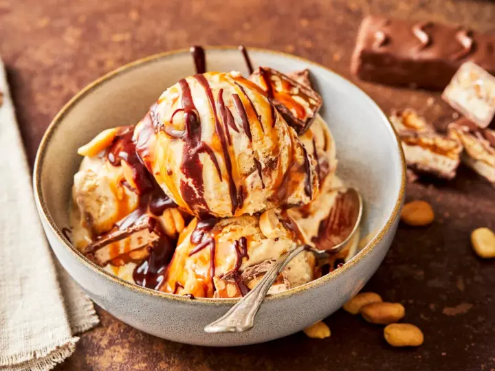 Schokoladiges Eis mit Karamell und Erdnüssen, perfekt für alle, die Snickers Eis selber machen wollen.