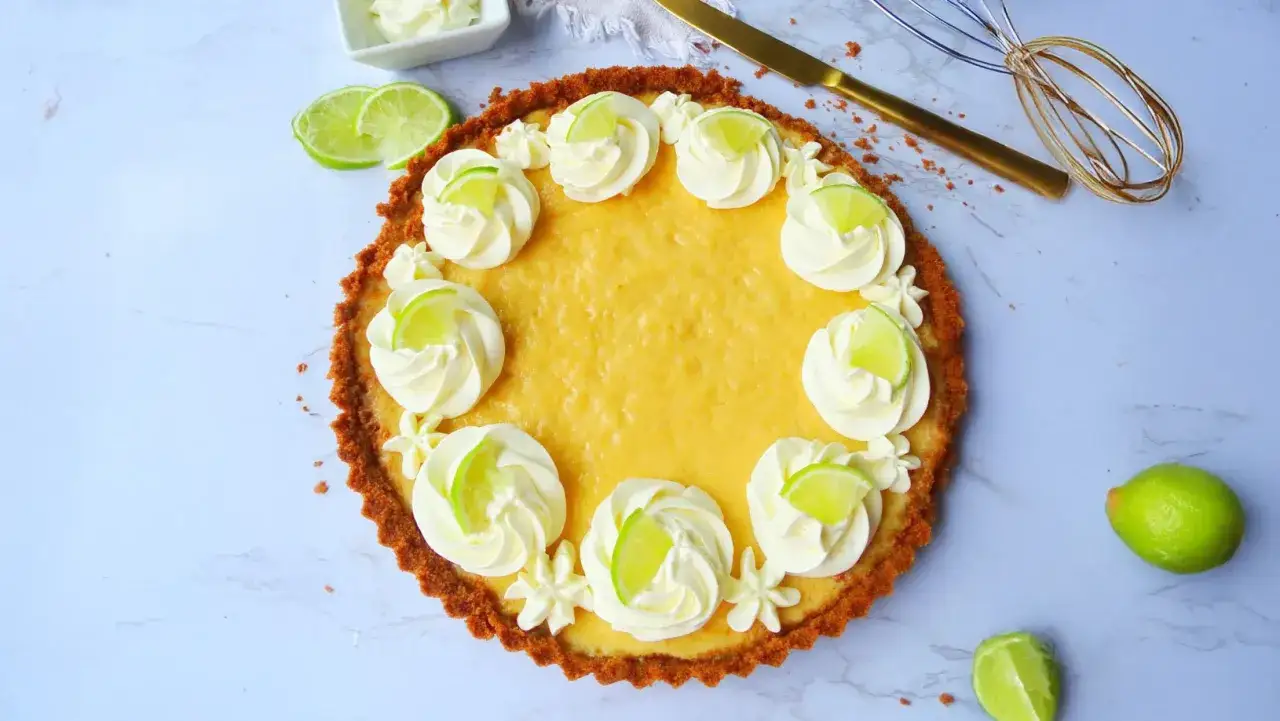 Ein köstlicher Key Lime Pie, verziert mit Sahnetuffs und Limettenscheiben, bereit zum Genießen.