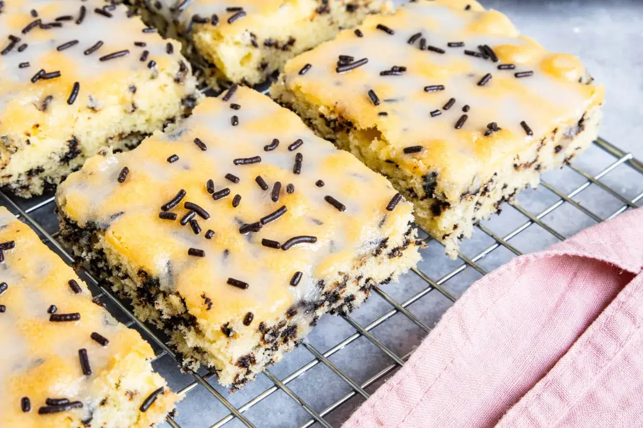 Süßer Ameisenkuchen vom Blech, mit Zuckerguss und Schokostreuseln, auf einem Kuchengitter.