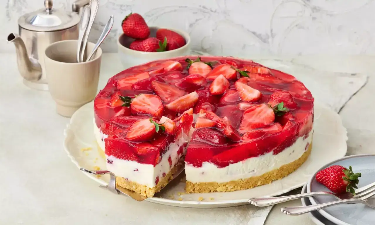 Ein saftiger erdbeerkuchen ohne backen, mit frischen Erdbeeren und rotem Tortenguss bedeckt. Ein Genuss für heiße Tage!