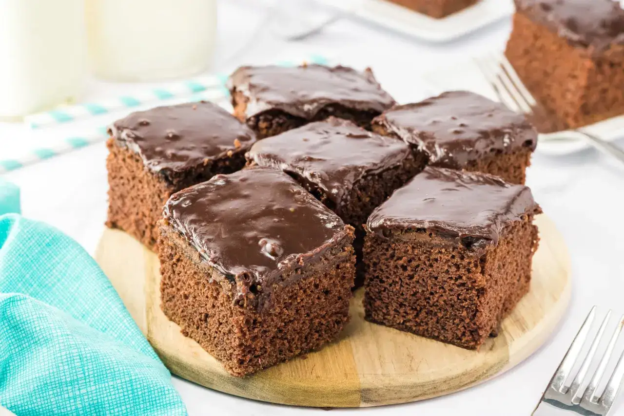 Saftige Buttermilch Brownies mit Schokoladenglasur auf einem Holzbrett, bereit zum Genießen.