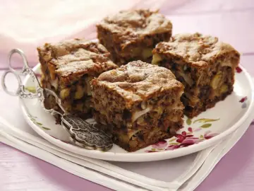Vier Stücke saftiger Apfel Walnuss Kuchen auf einem Teller mit Blumenmuster, daneben ein antiker Tortenheber.
